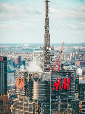 A stunning aerial shot of a New York City skyscraper featuring prominent H&M branding against the cityscape backdrop.