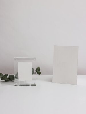 Elegant minimalist mockup featuring blank cards and acrylic frame on a white surface, ideal for presentations.