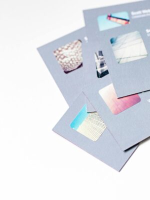 High angle view of abstract design business cards with cutouts on a white background.